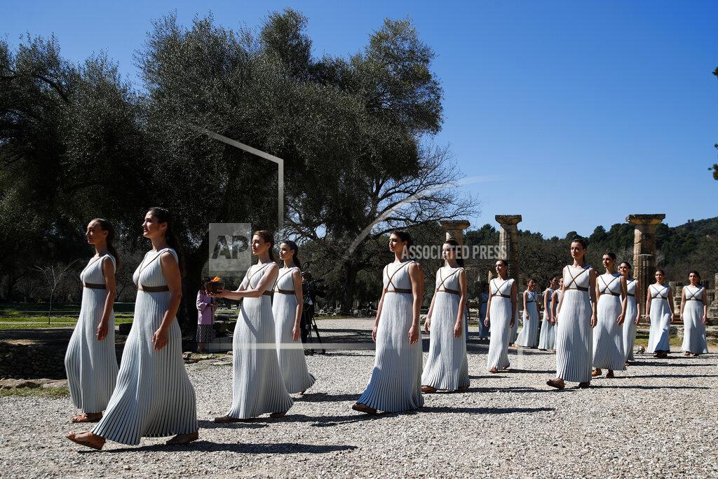 Thanassis Stavrakis Actresses, playing the role of priestesses, performance during the flame lighting ceremony at the closed Ancient Olympia site, birthplace of the ancient Olympics in southern Greece, Thursday, March 12, 2020, 2020. Greek Olympic officials are holding a pared-down flame-lighting ceremony for the Tokyo Games due to concerns over the spread of the coronavirus. Both Wednesday's dress rehearsal and Thursday's lighting ceremony are closed to the public, while organizers have slashed the number of officials from the International Olympic Committee and the Tokyo Organizing Committee, as well as journalists at the flame-lighting. (AP Photo/Thanassis Stavrakis)