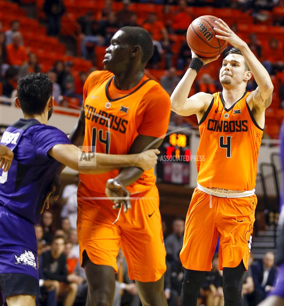 Nate Billings Oklahoma State's Thomas Dziagwa (4) shoots a three-point shot near Yor Anei (14) and TCU's Alex Robinson (25) in the first half of a NCAA college basketball game in Stillwater, Okla., Monday, Feb. 18, 2019. (Nate Billings/The Oklahoman via AP)