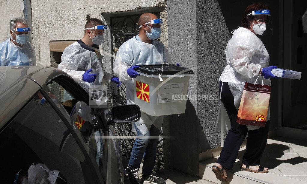 Boris Grdanoski Members of a special election team with a ballot box and voting material make their way to visit voters who have tested positive for COVID-19 or are in self-isolation, in Skopje, North Macedonia on Monday, July 13, 2020. North Macedonia holds its first parliamentary election under its new country name this week, with voters heading to the polls during an alarming spike of coronavirus cases in the small Balkan nation. Opinion polls in the run-up to Wednesday’s vote indicate a close race between coalitions led by the Social Democrats and the center-right opposition VMRO-DPMNE party. (AP Photo/Boris Grdanoski)