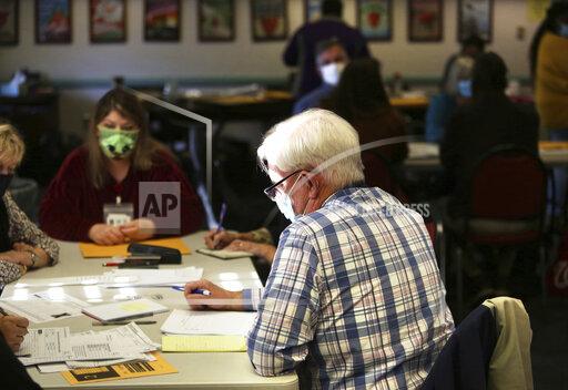 Election officials begin the process of recounting one of two unresolved races that will settle whether Virginia Republicans have reclaimed the majority in the House of Delegates, Thursday, Dec. 2, 2021 in Virginia Beach, Va. (Stephen M. Katz/The Virginian-Pilot via AP)