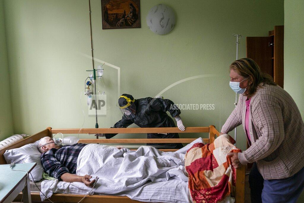 Evgeniy Maloletka A nurse, center, moves a bed with a coronavirus patient in a hospital intensive care unit in Stryi, western Ukraine, on Tuesday, Sept. 29, 2020. Coronavirus infections in Ukraine began surging in late summer, and the ripples are hitting towns in the western part of the country. The government wants to avoid imposing a new lockdown, but officials acknowledge that the rising infections could make it necessary. (AP Photo/Evgeniy Maloletka)