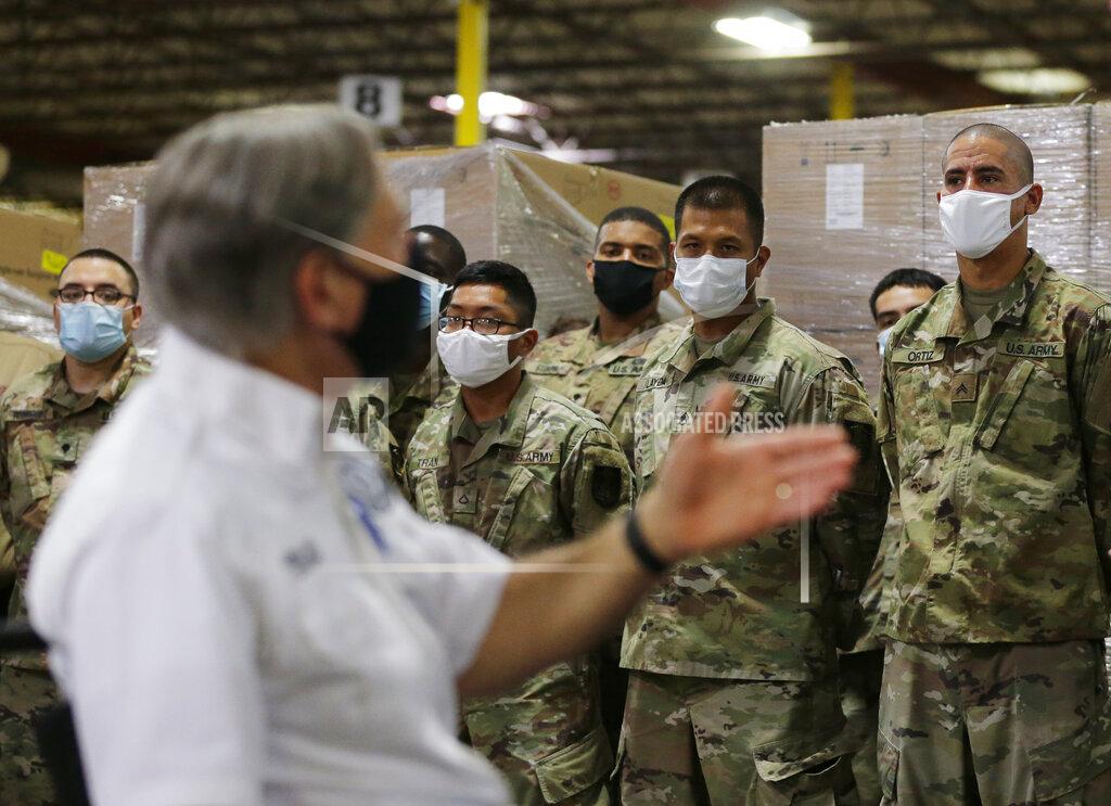 Eric Gay Texas Gov. Greg Abbott, foreground, addresses members of the National Guard during a visit to a Texas Division of Emergency Management Warehouse filled with Personal Protective Equipment, Tuesday, Aug. 4, 2020, in San Antonio. (AP Photo/Eric Gay)