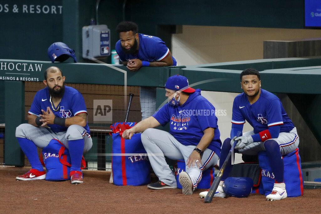 Tony Gutierrez Texas Rangers' Rougned Odor, left, Danny Santana, top, catching coach Hector Ortiz and Willie Calhoun, right, participate in an intrasquad game during baseball practice at Globe Life Field in Arlington, Texas, Friday, July 10, 2020. (AP Photo/Tony Gutierrez)