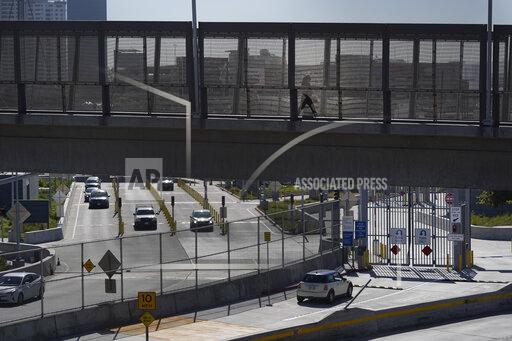 A few cars make their way north to cross into the United States from Tijuana, Mexico, Wednesday, Oct. 13, 2021, at the San Ysidro Port of Entry in San Diego. Beleaguered business owners and families separated by COVID-19 restrictions rejoiced Wednesday after the U.S. said it will reopen its land borders to nonessential travel next month, ending a 19-month freeze. (AP Photo/Gregory Bull)