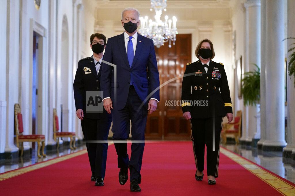 Patrick Semansky President Joe Biden walks with U.S. Air Force Gen. Jacqueline Van Ovost, left, and U.S. Army Lt. Gen. Laura Richardson before speaking at an event to mark International Women's Day, Monday, March 8, 2021, in the East Room of the White House in Washington. (AP Photo/Patrick Semansky)