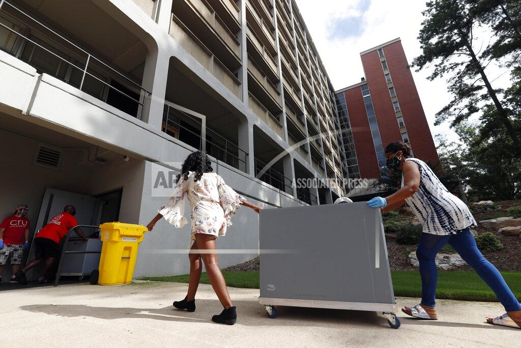 Gerry Broome FILE - In this Friday, July 31, 2020 file photo, College students begin moving in for the fall semester at N.C. State University in Raleigh, N.C. Colleges throughout the U.S. are assuring students that this coming fall will bring a return to in-person classes, intramural sports and mostly full dormitories. But those promises come with asterisks. (AP Photo/Gerry Broome, File)