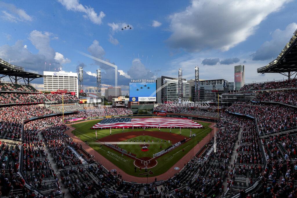 Butch Dill F-16s fly over during the national anthem before a baseball game between the Atlanta Braves and the St. Louis Cardinals, Monday, July 4, 2022, in Atlanta. (AP Photo/Butch Dill)