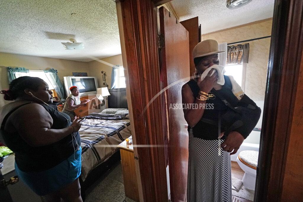 Gerald Herbert Rakisha Murray, right, reacts as she sees for the first time the damaged home of her sister, Patricia Mingo Lavergne, background, in Lake Charles, La., after they returned from evacuation in the aftermath of Hurricane Laura, Sunday, Aug. 30, 2020. (AP Photo/Gerald Herbert)