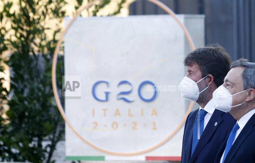 FILE - In this Thursday, July 29, 2021 file photo, Italian Culture Minister Dario Franceschini, left, welcomes Premier Mario Draghi as he arrives for the G20 Culture ministerial meeting at the Colosseum in Rome. A Group of 20 summit scheduled for this weekend, Oct. 30-31, 2021, in Rome is the first in-person gathering of leaders of the world’s biggest economies since the COVID-19 pandemic started. Russia and China aren’t coming. Turkey nearly set off a diplomatic incident on the eve of the meeting. And the U.S., Australia and France will be at the same table for the first time since Washington pulled the rug out from under Paris’ $66 billion submarine deal Down Under. (AP Photo/Riccardo De Luca, file)