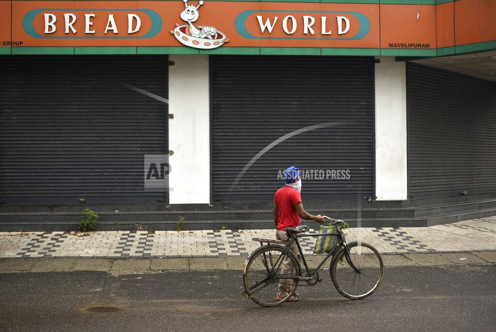 R S Iyer An Indian laborer walks with his bicycle past a bread shop before it opens in the morning in Kochi, Kerala state, India, Friday, May 22, 2020. India's central bank on Friday cut its key interest rate to 4% to revive the economy severely hit the coronavirus outbreak and a two-month lockdown. (AP Photo/R S Iyer)