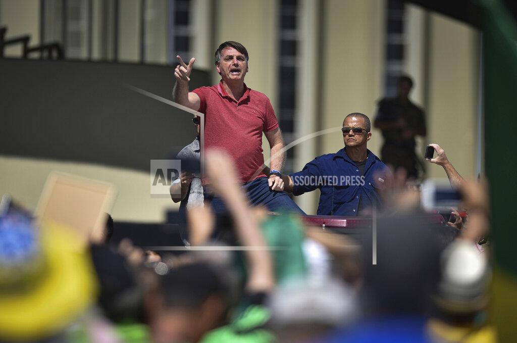 Andre Borges Brazil's President Jair Bolsonaro speaks to supporters during a protest in front the army's headquarters during the Army day, amid the new coronavirus pandemic, in Brasilia, Brazil, Sunday, April 19, 2020. Bolsonaro came out in support of a small protest Sunday that defended military intervention, infringing his own ministry's recommendations to maintain social distancing and prompting fierce critics. (AP Photo/Andre Borges)