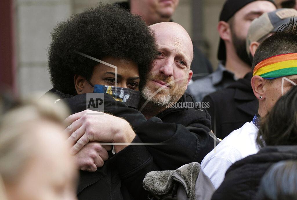 David Zalubowski Nic Grzecka, right, co-owner of Club Q, hugs a supporter after a 25-foot historic pride flag was unfurled to cover the exterior of City Hall to mark the weekend mass shooting at the gay nightclub Wednesday, Nov. 23, 2022, in Colorado Springs, Colo. The flag, known as Section 93 of the Sea to Sea Flag, is on loan for two weeks to Colorado Springs from the Sacred Cloth Project. (AP Photo/David Zalubowski)
