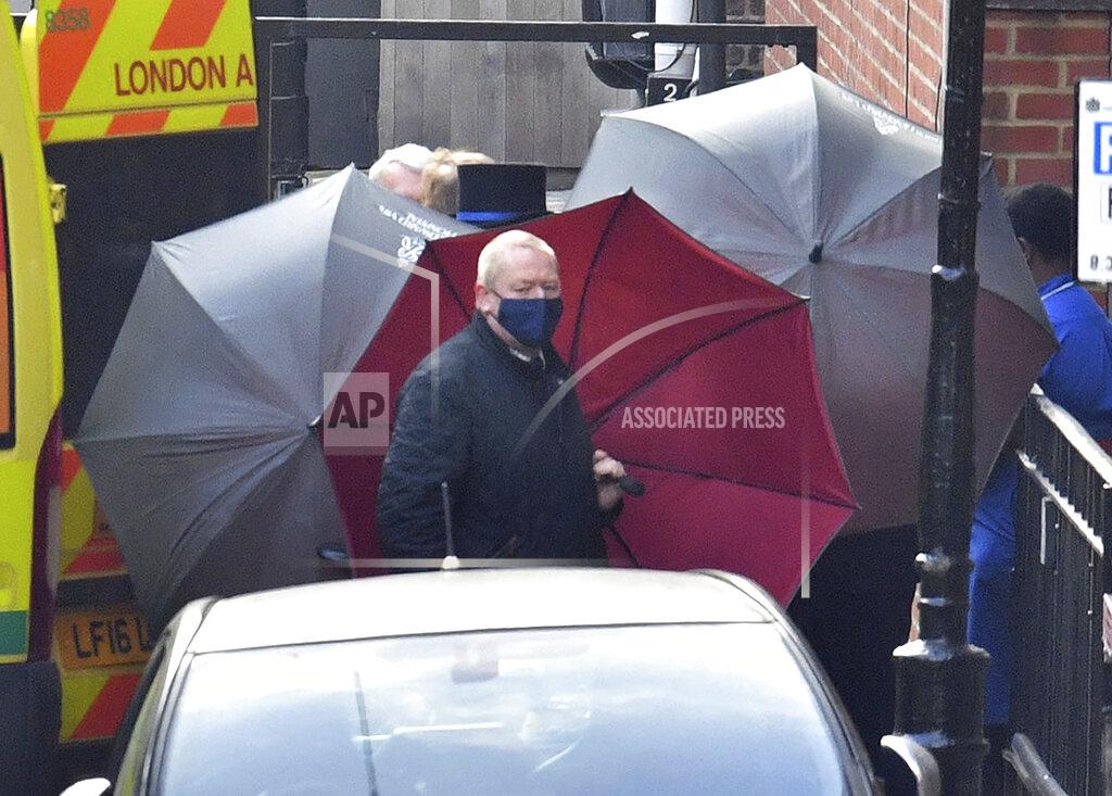 Dominic Lipinski Staff use umbrellas to shield entrance to an ambulance outside the rear of the King Edward VII Hospital in London where Prince Philip is being treated Monday March 1, 2021. (Dominic Lipinski/PA via AP)