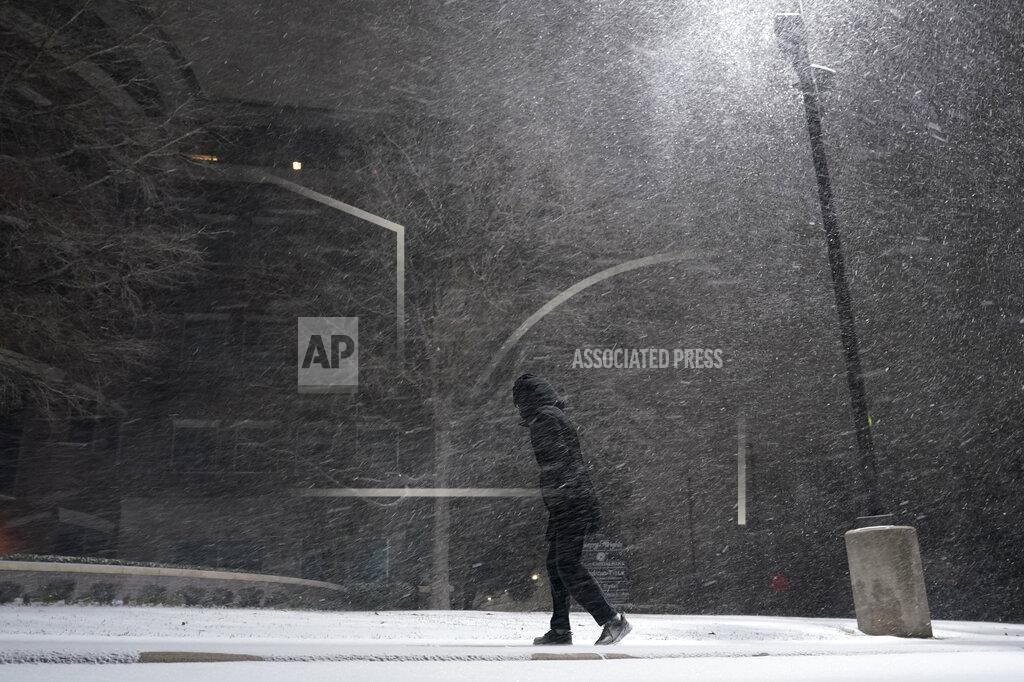 Eric Gay A woman walks through falling snow in San Antonio, Sunday, Feb. 14, 2021. Snow and ice blanketed large swaths of the U.S. on Sunday, prompting canceled flights, making driving perilous and reaching into areas as far south as Texas’ Gulf Coast, where snow and sleet were expected overnight. (AP Photo/Eric Gay)