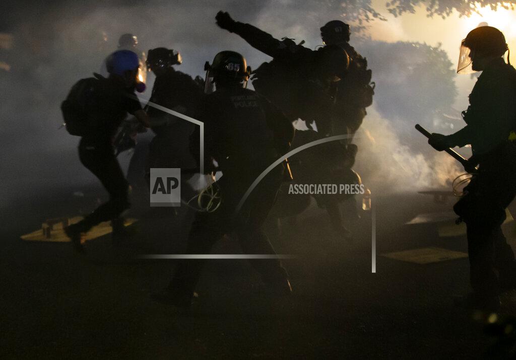 Dave Killen Police declared a riot around midnight as Portland protests continued for the 80th consecutive night Saturday, Aug. 15, 2020. Protesters gathered at Laurelhurst Park Saturday evening before marching to the Penumbra Kelly building. (Dave Killen/The Oregonian via AP)