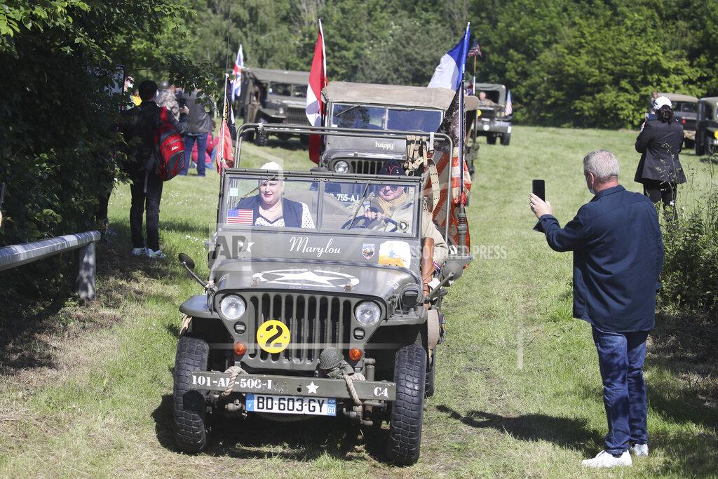 David Vincent People parade in WWII vehicles in Colleville-Montgomery,, Normandy, Saturday June, 5 2021 on the eve of 77th anniversary of the assault that helped bring an end to World War II.. While France is planning to open up to vaccinated visitors starting next week, that comes too late for the D-Day anniversary. So for the second year in a row, most public commemoration events have been cancelled. A few solemn ceremonies have been maintained, in the presence of dignitaries and a few guests only. (AP Photo/David Vincent)