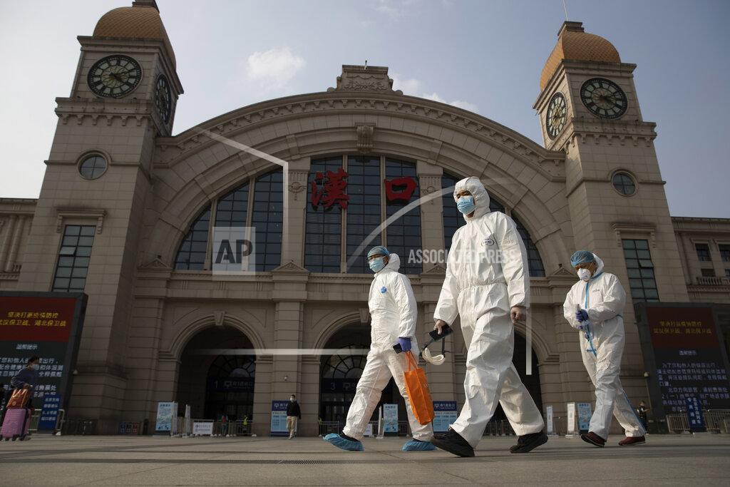 Ng Han Guan FILE - April 7, 2020, file photo, workers in protective overalls walk past the Hankou railway station on the eve of its resuming outbound traffic in Wuhan in central China's Hubei province. One year after Wuhan’s lockdown to curb the coronavirus, the Chinese city has long since sprung back to life. (AP Photo/Ng Han Guan, File)