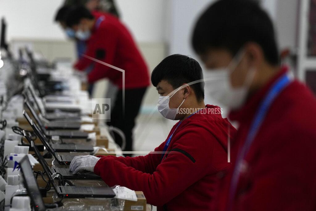Ng Han Guan Workers prepare laptops at the Main Distribution Center built to provide logistic support for the upcoming Beijing Winter Olympics and Paralympics in Beijing, China, Thursday, Dec. 9, 2021. The 34-meter-tall building has started operation at the end of last year to receive, store and distribute furniture, sport and technical equipment, and other materials for the current test events and next year's Winter Games. (AP Photo/Ng Han Guan)