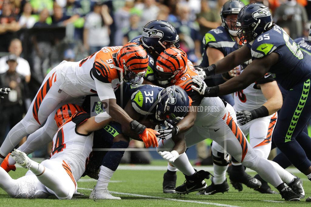 John Froschauer Seattle Seahawks running back Chris Carson (32) is tackled by Cincinnati Bengals' Carlos Dunlap (96) and Geno Atkins (97) during the first half of an NFL football game Sunday, Sept. 8, 2019, in Seattle. (AP Photo/John Froschauer)