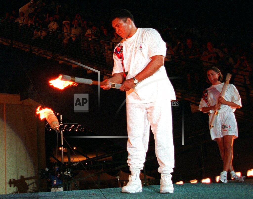 Michael Probst Boxing legend Muhammed Ali lights the Olympic flame, as American swimmer Janet Evans looks on during the 1996 Summer Olympic Games opening ceremony in Atlanta, July 19, 1996. (AP Photo/Michael Probst)