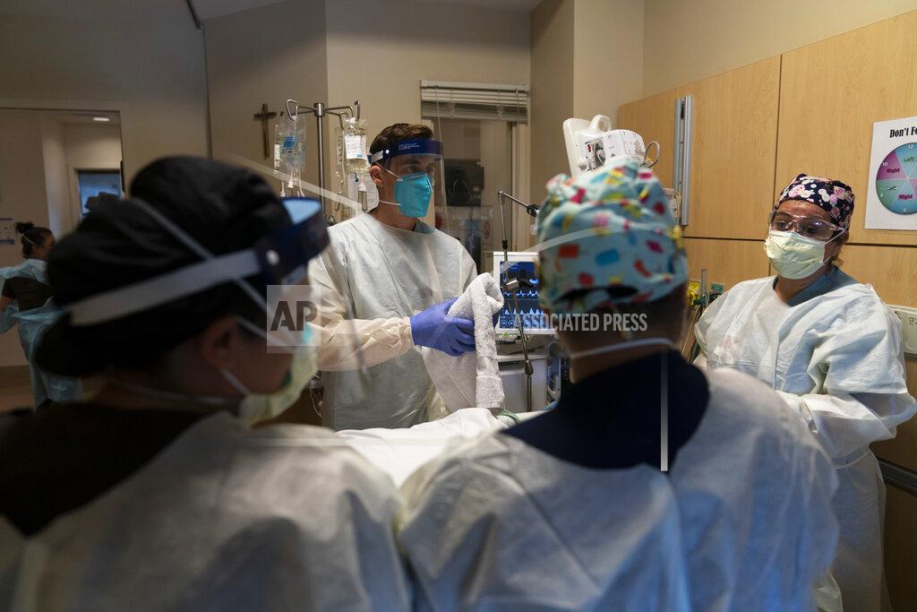 FILE - In this Nov. 19, 2020, file photo, medical personnel prepare to prone a COVID-19 patient at Providence Holy Cross Medical Center in the Mission Hills section of Los Angeles. California is desperately searching for nurses, doctors and other medical staff, perhaps from overseas, to meet demands as the coronavirus surge pushes hospitals across the state to the breaking point. With many of the state's hospitals running out of capacity to treat the severest cases, the state has brought in and deployed more than 500 extra staff but it needs a total of 3,000 temporary medical staff members. (AP Photo/Jae C. Hong)