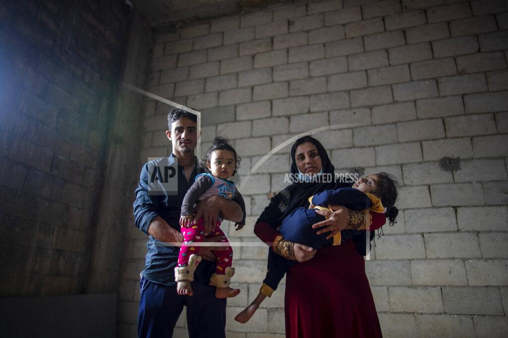 Hassan Ammar Syrian refugees Raed Mattar, 24, left, poses for a photograph with his wife Ayesha al-Abed, 21, and their daughters Rahaf, 6 years old, right, and Rayan, 18 months old, at an informal refugee camp, in the town of Rihaniyye in the northern city of Tripoli, Lebanon, Tuesday, April 13, 2021. For many Syrian refugee families in Lebanon, Ramadan comes as a hard life of displacement has gotten even harder after a pandemic year that deepened economic woes in their host country. (AP Photo/Hassan Ammar)