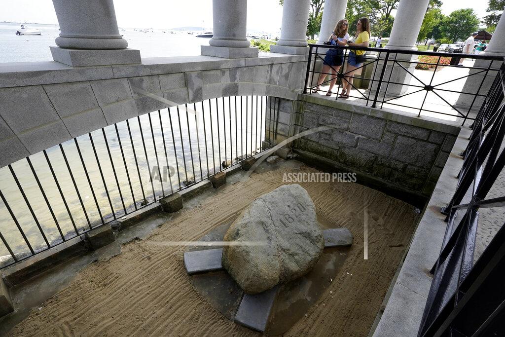 Steven Senne Visitors stand in a pavilion that shelters Plymouth Rock, below, in Plymouth, Mass., Wednesday, June 9, 2021. Archaeologists are excavating the grassy hilltop that overlooks iconic Plymouth Rock one last time before a historical park is built on the site. (AP Photo/Steven Senne)
