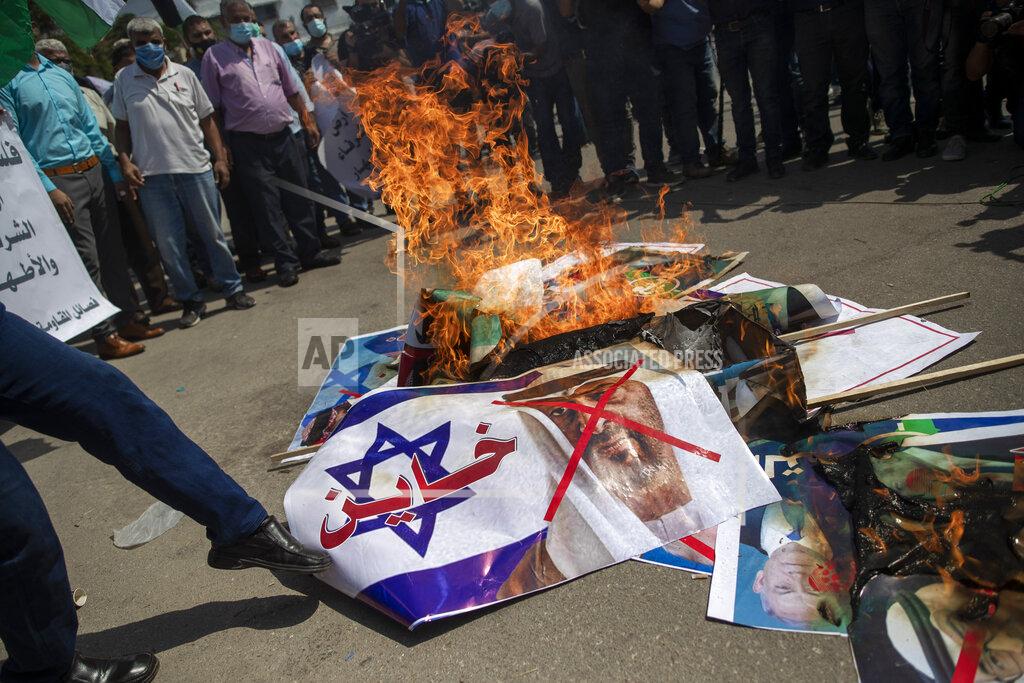 Khalil Hamra Palestinians burn pictures of U.S. President Donald Trump, Israeli Prime Minister Benjamin Netanyahu, Bahrain's King Hamad bin Isa Al Khalifa and and Abu Dhabi Crown Prince Mohammed bin Zayed al-Nahyan, during a protest against the United Arab Emirates and Bahraini normalization agreement with Israel, in Gaza City, Tuesday, Sept. 15, 2020. Israel is set to sign agreements with the UAE and Bahrain at the White House on Tuesday. Arabic on poster with representation of an Israeli flag reads, "traitor." (AP Photo/Khalil Hamra)