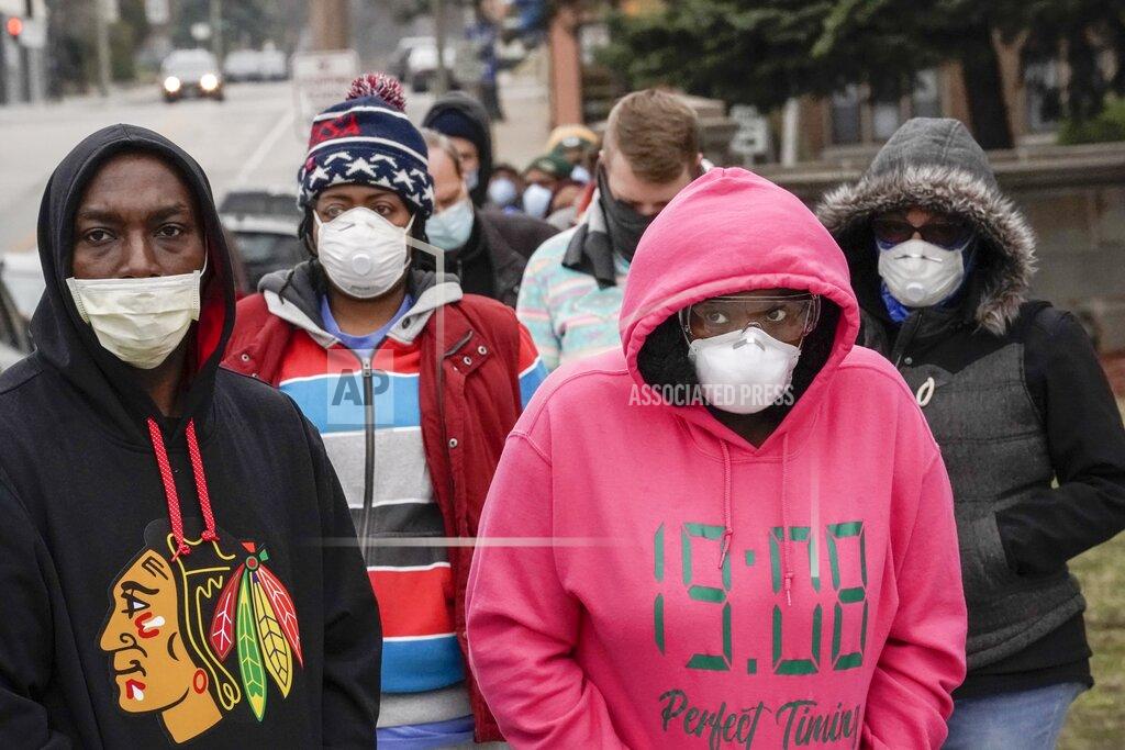 Morry Gash FILE - In this April 7, 2020 file photo, voters wearing masks as a precaution against the coronavirus, line up at Riverside High School for Wisconsin's primary election in Milwaukee. The Wisconsin Supreme Court on Wednesday, March 31, 2021, struck down Gov. Tony Evers' statewide mask mandate, ruling that the Democrat exceeded his authority by issuing the order. The 4-3 ruling from the conservative-controlled court is the latest legal blow to attempts by Evers to control the coronavirus..(AP Photo/Morry Gash File)