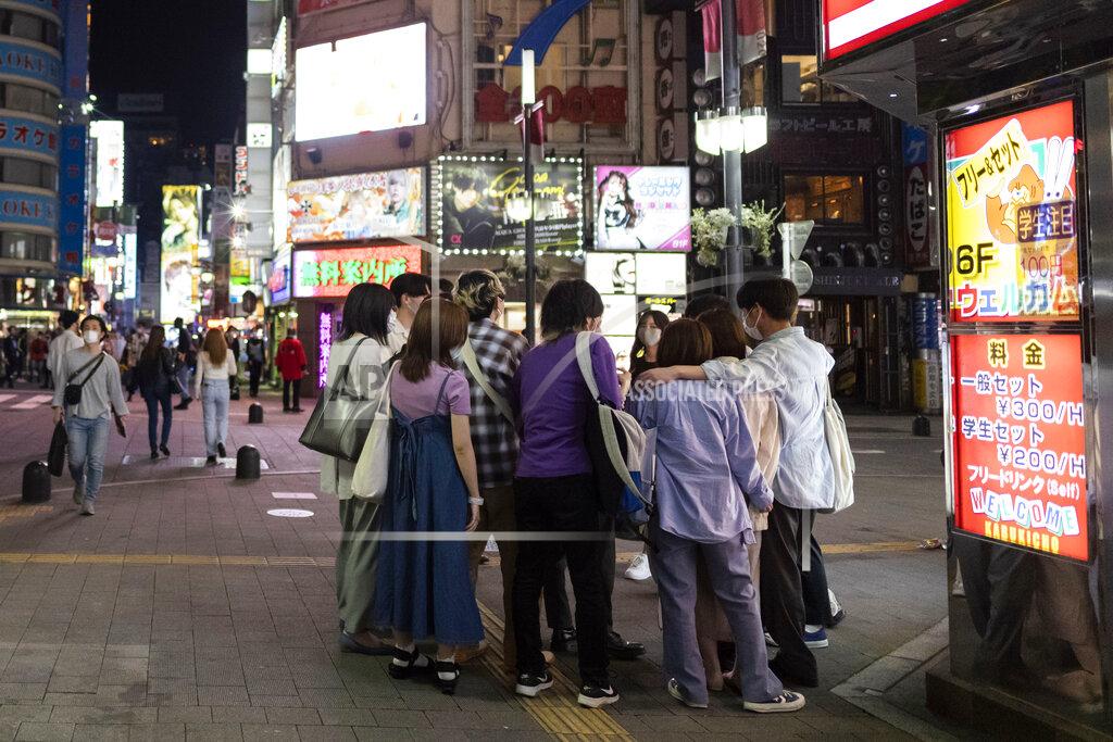 People gather on a street corner in the famed Kabukicho, a night entertainment district in downtown Tokyo, Friday, May 28, 2021, after the 8 p.m. government suggested closing time for restaurants, bars and non-essential businesses under the extended state of emergency. In Tokyo, life in the evening is continuing almost as usual as people in one of the world’s least vaccinated countries show increasing signs of frustration and defy largely toothless emergency measures. (AP Photo/Hiro Komae)