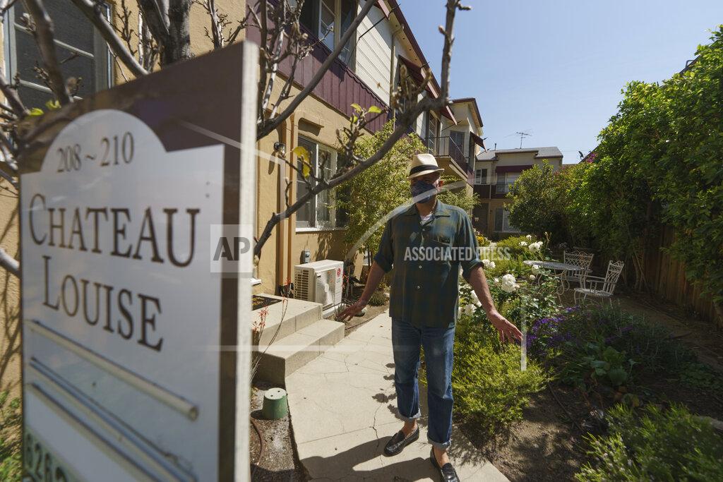 Damian Dovarganes Nathan Long, a video game writer, walks outside his rental apartment communal garden in Glendale, Calif., Thursday, April 8, 2021. He and his wife, Lili, have been unsuccessful so far in their search for a home in Los Angeles. (AP Photo/Damian Dovarganes)