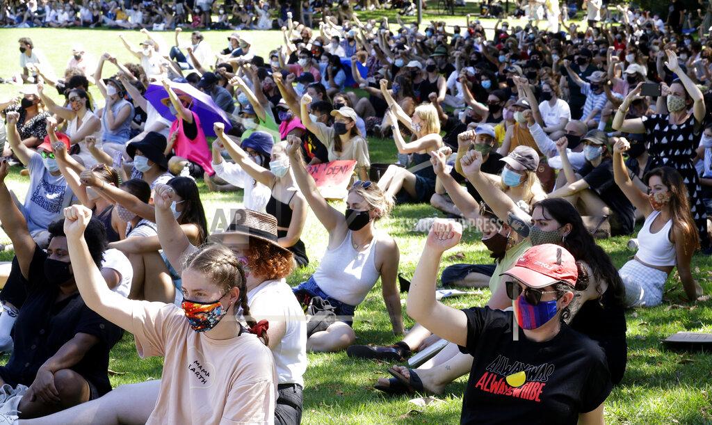 Rick Rycroft Members of the crowd raise their fists during an Aboriginal-lead Invasion Day rally on Australia Day in Sydney, Tuesday, Jan. 26, 2021. Many of Australia's First Nations people say that sovereignty has never been ceded and oppose ongoing colonial violence and destruction. (AP Photo/Rick Rycroft)