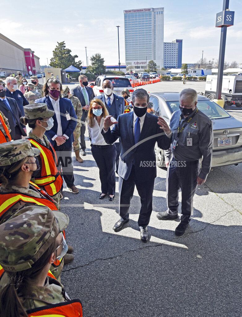 Walt Unks Gov. Roy Cooper talks with Air Force personnel stationed and Langley and Nellis Air Force bases who were brought in to work the FEMA-supported mass vaccination site at Four Season Town Centre mall, Wednesday, March 10, 2021. Wednesday was the first full day of vaccinations at the site which includes both indoor and drive-thru vaccinations. (Walt Unks/Winston-Salem Journal via AP)