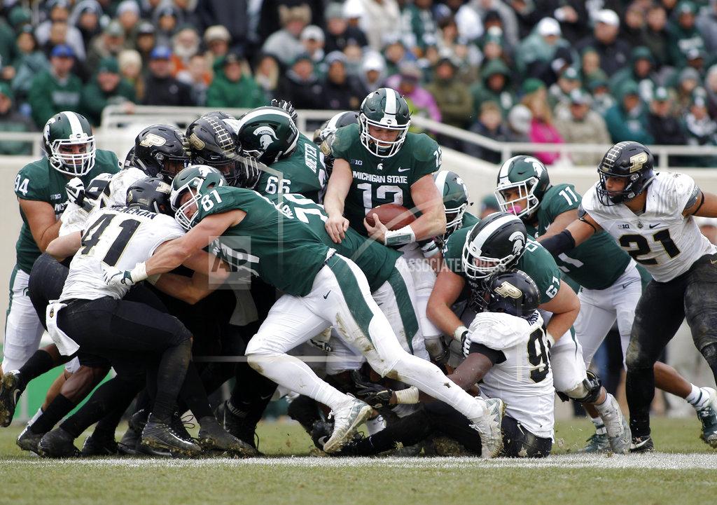 Al Goldis Michigan State quarterback Rocky Lombardi (12) emerges from the pile on a quarterback sneak for a first down against Purdue during the fourth quarter of an NCAA college football game, Saturday, Oct. 27, 2018, in East Lansing, Mich. Michigan State won 23-13. (AP Photo/Al Goldis)