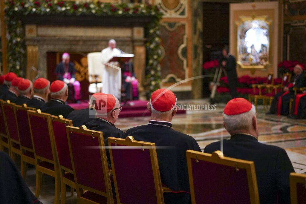 FILE - Cardinals listen as Pope Francis, background, delivers his Christmas greetings to the Roman Curia, in the Clementine Hall at the Vatican, Saturday, Dec. 21, 2019. Pope Francis has ordered pay cuts for Holy See employees, including slashing cardinals’ salaries by 10%. Francis in a letter made public by the Vatican on Wednesday, March 24, 2021, noted that the pandemic emergency “negatively impacted all sources of revenue” for the Holy See and Vatican City State. (AP Photo/Andrew Medichini, File)