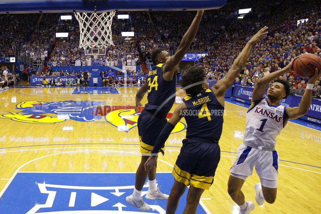 Charlie Riedel Kansas' Devon Dotson (1) shoots under pressure from West Virginia's Miles McBride (4) and Oscar Tshiebwe (34) during the first half of an NCAA college basketball game Saturday, Jan. 4, 2020, in Lawrence, Kan. (AP Photo/Charlie Riedel)