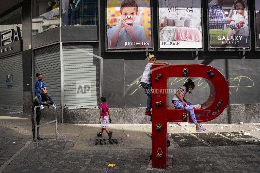 Matias Delacroix FILE - Children play on the letter "P" that is part of the acronym for the state-run oil company Petroleos de Venezuela S.A. (PDVSA) on the sidewalk in Caracas, Venezuela, Jan. 2, 2022. The United States government is moving to ease a few economic sanctions on Venezuela, which sits atop the world’s largest oil reserves and where about three quarters of its population live on less than $1.90 a day and lack access to clean, running water and electricity. (AP Photo/Matias Delacroix, File)