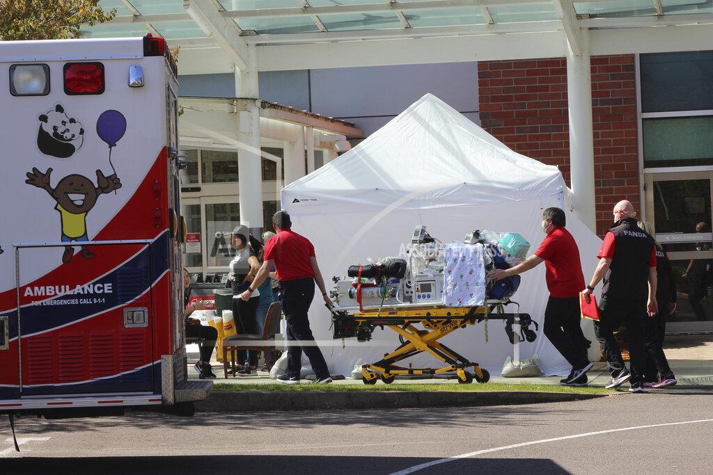 Andrew Selsky FILE - In this April 9, 2020, file photo, healthcare workers wheeling a gurney into Salem Hospital's emergency room in Salem, Ore., during the coronavirus outbreak. Oregon health officials reported its second-highest tally of confirmed cases of COVID-19 and five additional deaths on Friday, June 26, 2020, the same day that authorities released new modeling that shows increased transmission of the coronavirus since the state began reopening in mid-May. (AP Photo/Andrew Selsky, File)