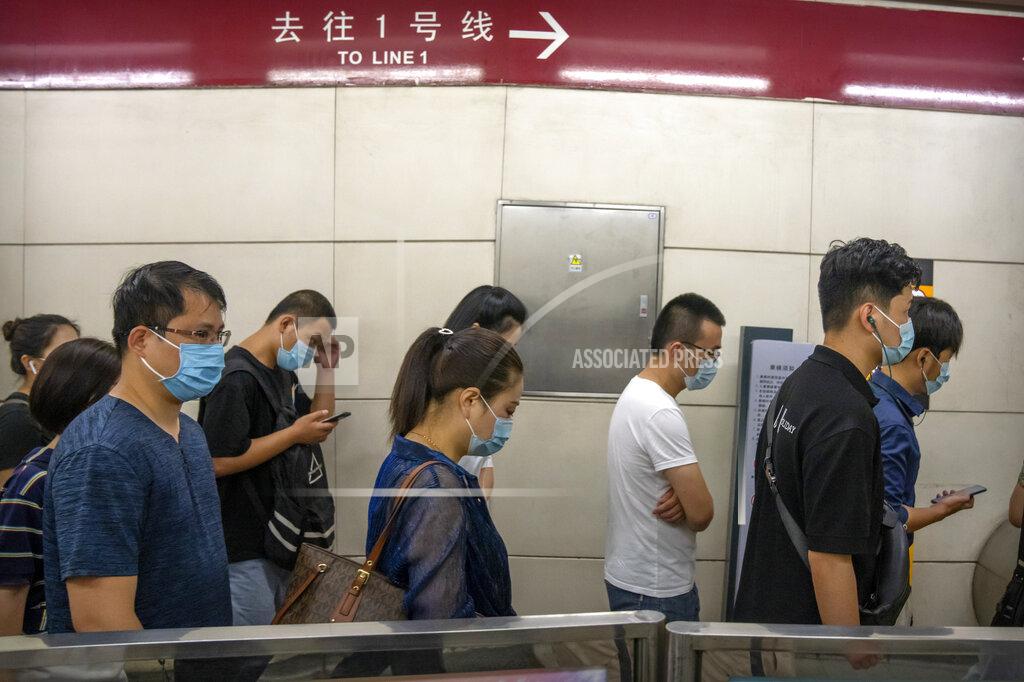 Mark Schiefelbein People wearing face masks to help protect against COVID-19 walk through a subway station during the morning rush hour in Beijing, Wednesday, Aug. 4, 2021. China's worst coronavirus outbreak since the start of the pandemic a year and a half ago escalated Wednesday with dozens more cases around the country, the sealing-off of one city and the punishment of its local leaders. (AP Photo/Mark Schiefelbein)