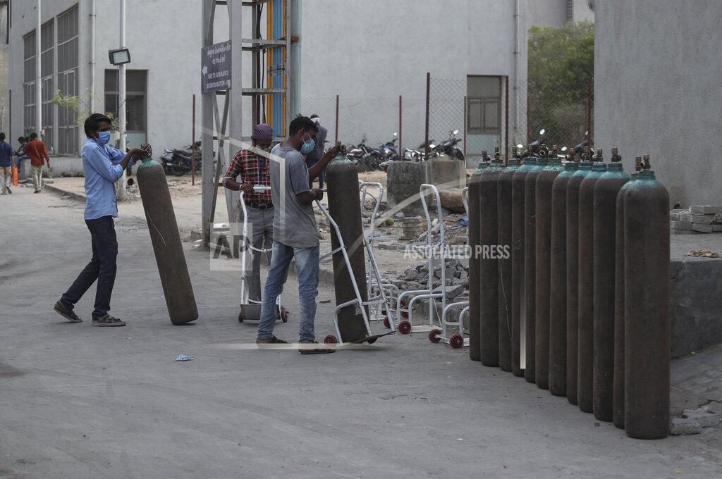 Ajit Solanki Workers stack empty oxygen cylinders near an oxygen plant at a government COVID-19 hospital in Ahmedabad, India, Tuesday, April 27, 2021. The COVID-19 death toll in India has topped 200,000 as the country endures its darkest chapter of the pandemic yet. (AP Photo/Ajit Solanki)