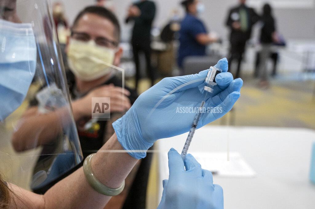 Hector Amezcua Claudio Alvarado, left, a registered nurse at UC Davis Medical Center, waits to be inoculated with the Pfizer-BioNTech Covid-19 vaccine by Heather Donaldson, registered nurse at UC Davis Medical Center, Tuesday, Dec. 15, 2020 in Sacramento, Calif. (AP Photo/Hector Amezcua, Pool)
