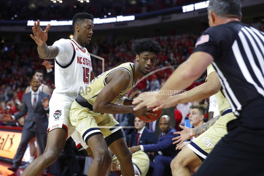 Georgia Tech's Khalid Moore (12) pulls in a loose ball after North Carolina State's Devon Daniels tried to throw the ball to Manny Bates (15) with less than 10 seconds left in an NCAA college basketball game Tuesday, Nov. 5, 2019, in Raleigh, N.C. (Ethan Hyman/The News & Observer via AP)
