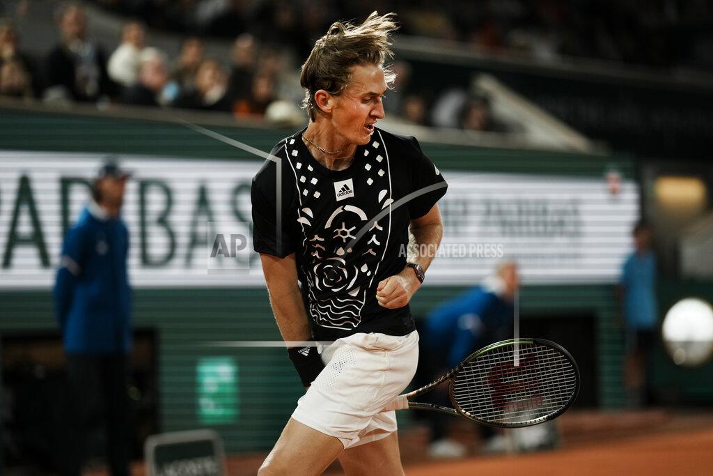 Thibault Camus Sebastian Korda of the U.S. runs to the back of the court and return the ball through his legs during his third round match against Spain's Carlos Alcaraz at the French Open tennis tournament in Roland Garros stadium in Paris, France, Friday, May 27, 2022. (AP Photo/Thibault Camus)