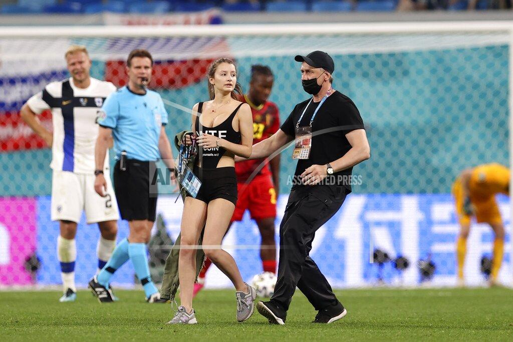 Lars Baron A woman enters the pitch as a security stops her during the Euro 2020 soccer championship group B match between Finland and Belgium at Saint Petersburg stadium, in St. Petersburg, Russia, Monday, June 21, 2021 (Lars Baron/Pool via AP)