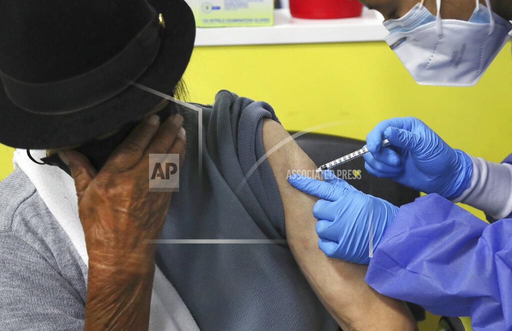 Dolores Ochoa An elderly woman covers her face as she is inoculated with a dose of the Pfizer COVID-19 vaccine at the convention center converted into a vaccination site, in Quito, Ecuador, Wednesday, March 31, 2021. (AP Photo/Dolores Ochoa)