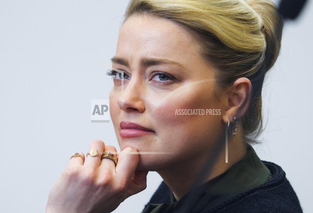 Evelyn Hockstein Actor Amber Heard listens to her ex-husband actor Johnny Depp's testimony in the courtroom in the Fairfax County Circuit Courthouse in Fairfax, Va., Wednesday, May 25, 2022. Depp sued Heard for libel in Fairfax County Circuit Court after she wrote an op-ed piece in The Washington Post in 2018 referring to herself as a "public figure representing domestic abuse." (Evelyn Hockstein/Pool photo via AP)