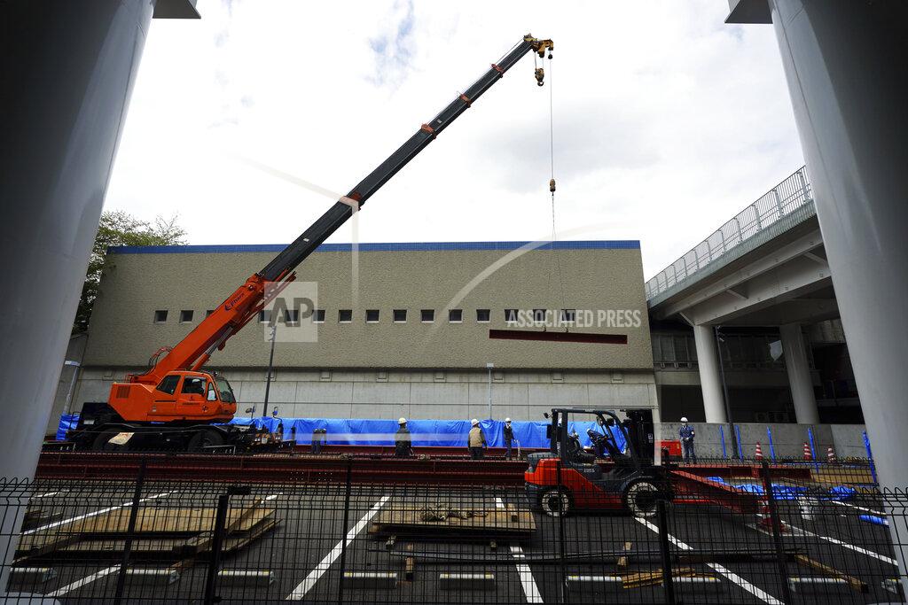 Eugene Hoshiko Construction workers lift a steel beam into position at Tokyo Metropolitan Gymnasium, one of venues for the postponed Tokyo 2020 Olympics Tuesday, April 6, 2021, in Tokyo. Many preparations are still up in the air as organizers try to figure out how to hold the postponed games in the middle of a pandemic. (AP Photo/Eugene Hoshiko)