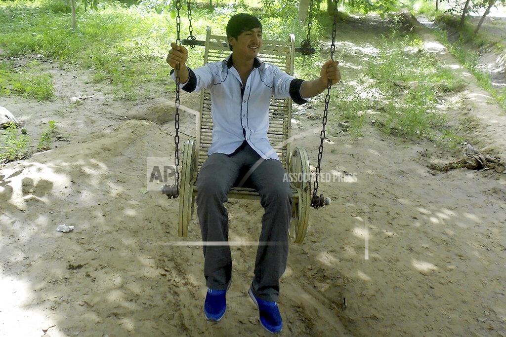 Uncredited In this photo released by Nursimangul Abdureshid, Uyghur Memetali Abdureshid sits on a swing in Hotan in China's far west Xinjiang region in July 2013. Nearly one in 25 people in a county in the Uyghur heartland of China has been sentenced to prison on terrorism-related charges, in what is the highest known imprisonment rate in the world, an Associated Press review of leaked data shows. Abdureshid, who ran a car repair shop, was listed as being sentenced to 15 years and 11 months in prison on charges of "picking quarrels and provoking trouble” and “preparing to carry out terrorist activities." (Nursimangul Abdureshid via AP)