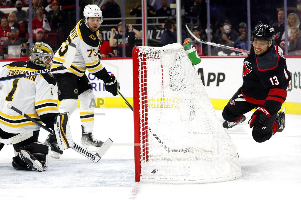 Karl B Deblaker Carolina Hurricanes' Max Domi (13) dives over the net after getting the puck past Boston Bruins' Charlie McAvoy (73) and goaltender Jeremy Swayman (1) for a goal during the second period of Game 7 of an NHL hockey Stanley Cup first-round playoff series in Raleigh, N.C., Saturday, May 14, 2022. (AP Photo/Karl B DeBlaker)
