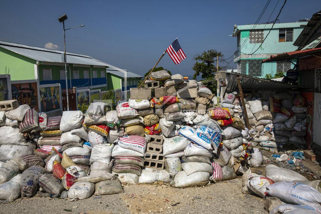 Rodrigo Abd A U.S. national flag tops a barricade delimiting territorial gang control in the Bel Air neighborhood of Port-au-Prince, Haiti, Saturday, Sept. 25, 2021. More than a city, Port-au-Prince is an archipelago of gang-controlled islands. Some neighborhoods are abandoned. Others are barricaded behind fires, destroyed cars and piles of garbage, occupied by heavily armed men. (AP Photo/Rodrigo Abd)